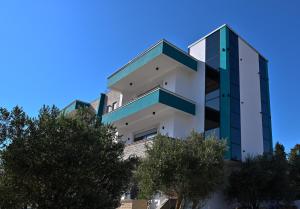 a tall building with trees in front of it at Stars Five Stay in Ulcinj