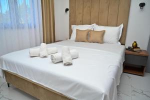 a bedroom with a large white bed with towels on it at Stars Five Stay in Ulcinj