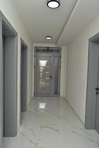 an empty hallway with a door and marble floor at Stars Five Stay in Ulcinj