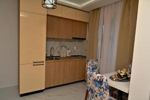 a kitchen with a sink and a table with a chair at Stars Five Stay in Ulcinj
