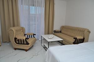 a hotel room with a bed and chairs and a table at Stars Five Stay in Ulcinj