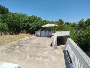 a patio with a table and an umbrella at Kuća Duskic in Kunje