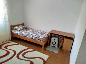a bedroom with a bed and a table and a rug at Kuća Duskic in Kunje