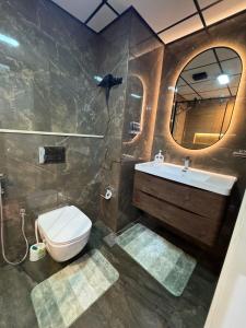 Un baño con inodoro, lavabo y espejo. en 5 Star Comfort - Luxury Sea View, en Ajman 9 fotos más