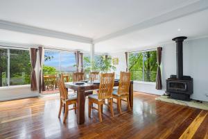 a dining room with a table and chairs and a wood stove at 4BR2BA Farmhouse Private Deck Shared Games Room H2 in Bilpin