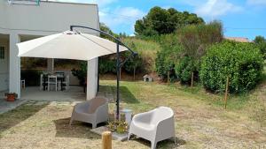 a patio with two chairs and an umbrella at Da Lucia in Francavilla al Mare