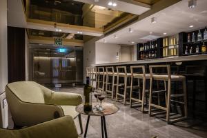 a bar with chairs and a table with wine bottles at Golden Crown Haifa in Haifa