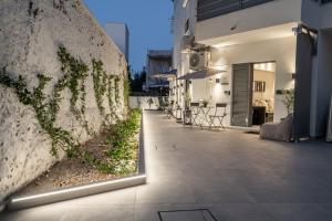a courtyard of a building with a wall with plants at Monte Smith Luxury Suites in Rhodes Town