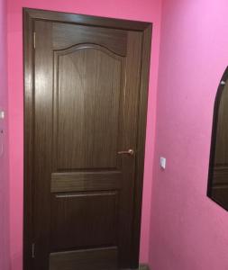 モンチェゴルスクにあるApartments on pr.Metallurgovのピンクの壁の部屋の木製ドア
