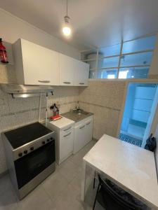 a kitchen with white cabinets and a sink and a table at Charmant studio deux min métro in Aubervilliers +15 photos