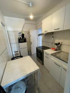 a kitchen with white cabinets and a counter top at Charmant studio deux min métro in Aubervilliers