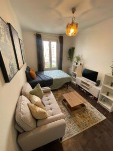 a living room with a couch and a bed at Charmant studio deux min métro in Aubervilliers