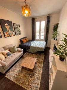 a living room with a couch and a table at Charmant studio deux min métro in Aubervilliers