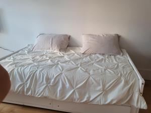 a white bed with two pillows on top of it at Super appartement proche metro in Montréal