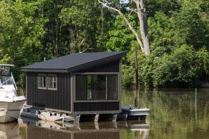 a small cabin on a boat in the water at Floating Tiny Home #1 in Vermilion