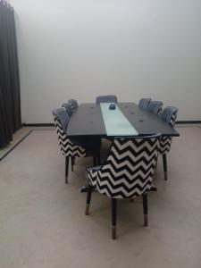 a black table with chairs in a room at Ayyan Cottage G 10-2 in Islamabad