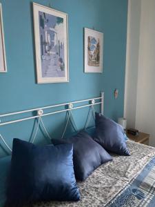 a bedroom with blue walls and a bed with blue pillows at Sole Mare da Tina in Cittadella del Capo