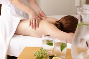 Eine Frau bekommt eine Massage im Bett in der Unterkunft Chloe Luxury Hotel in Kastoria