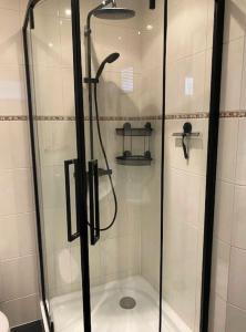 a shower with a glass door in a bathroom at De Reesterhoeve in Balkbrug