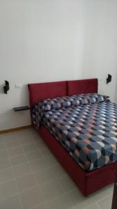 a red bed in a room with a checkered mattress at Casa vacanze " il muretto" in Gallipoli