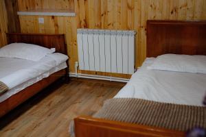 two beds in a room with wooden walls and wood floors at Ghazaryan's Home Guesthouse Lori in Debed