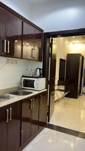 una cucina con lavello e microonde di التميز للشقق فرع ثاني المخدومة a Al Majmaah