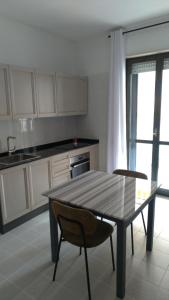 a kitchen with a table and two chairs and a table at Casa vacanze " il muretto" in Gallipoli