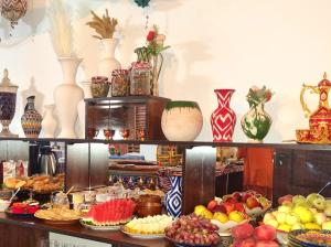 a shelf filled with lots of vases and fruit at Oasis al Khiva Boutique Hotel Inside Citadel in Khiva