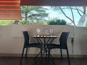 - une table avec 2 chaises et des verres à vin dans l'établissement Bed & Movie, à Rome