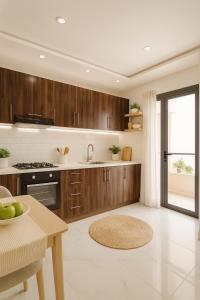 eine große Küche mit Holzschränken und einem Tisch in der Unterkunft aslan appart in Martil