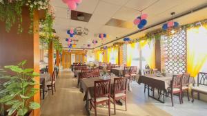 a dining room with tables and chairs and flowers at Hotel Grand Circle Inn in Dhaka