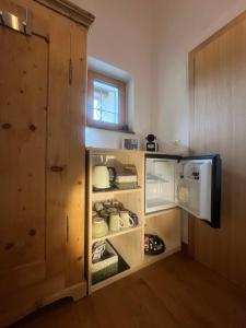 a kitchen with an open refrigerator and a microwave at Bed and Breakfast Il Cardellino in San Carlo