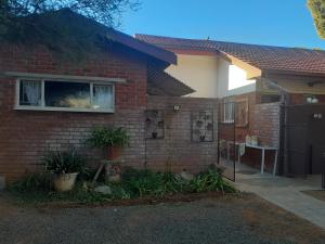 una casa de ladrillo con una ventana y una valla en 3 Lavenders, en Bloemfontein