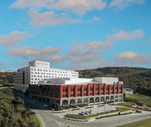 本图贡萨尔维斯Plaza Hotel & Boulevard Convention - Vale dos Vinhedos的前面有一条路的白色大建筑