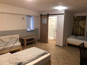 a bedroom with two beds and a door to a bathroom at Kwatery Mamma Mia Opawska 1a in Krzanowice