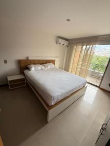 a bedroom with a large bed and a large window at Mirador pueblito Paisa-Tipo loft in Medellín +43 photos