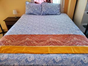 a bed with a blue and orange comforter on it at Bayview Luxury Retreats 
