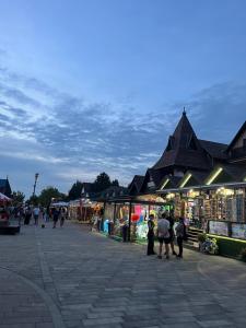 a group of people walking around a market with shops at Centrum Motel in Balatonfenyves