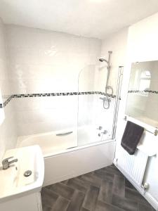un bagno bianco con doccia e lavandino di Wirral snug stay a Wallasey