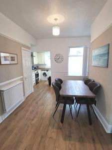 un soggiorno con tavolo da pranzo e sedie di Wirral snug stay a Wallasey Altre 11 foto