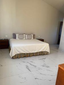 a white bedroom with a bed with marble floors at Beautiful home in El Tigre golf course Nuevo Vallarta! in Nuevo Vallarta 