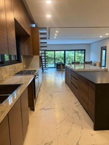 a large kitchen with wooden cabinets and a large island at Beautiful home in El Tigre golf course Nuevo Vallarta! in Nuevo Vallarta 