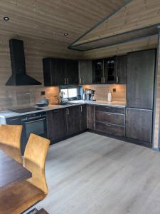 a large kitchen with wooden cabinets and a wooden floor at 2 cabins surrounded by beautiful nature in Stryn +25 photos
