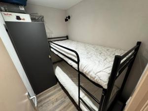 a small room with two bunk beds and a refrigerator at Résidence Villaret - 2 Pièces pour 4 Personnes MAE-4101 in Les Menuires +9 photos