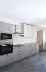 una cocina con armarios de acero inoxidable y fregadero en Fly in Apartment, en Čilipi