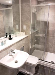 a bathroom with a sink and a shower and a toilet at 2Bed 2Bath Private Balcony, Relaxing Waterfront View Apt, Parking FREE WiFi 10mins Media City, Salford Quays, Old Trafford, City Centre in Manchester +38 photos
