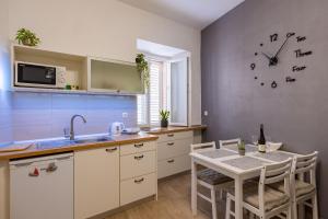 une cuisine avec une table et une horloge au mur dans l'établissement Solis Apartment, à Korčula 15 autres photos