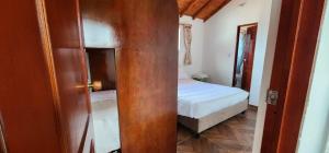 una piccola stanza con un letto e una porta con una camera da letto di El Pedregal de la Villa a Villa de Leyva