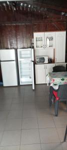 a kitchen with white cabinets and a table and a refrigerator at Casa Vio in Eforie Nord +14 photos