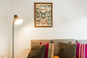 een bank met kussens en een foto aan de muur bij Cozy 2BR Relaxing Vibe in Lima +55 foto's